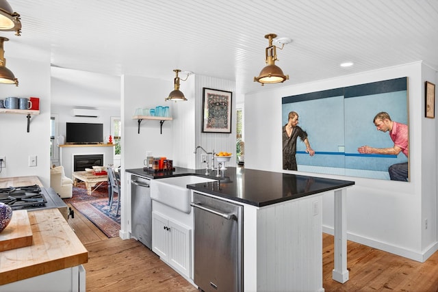 7 Anthony St, Provincetown, MA 02657 - kitchen with a wall mounted AC, appliances with stainless steel finishes, white cabinets, light wood-style floors, and recessed lighting