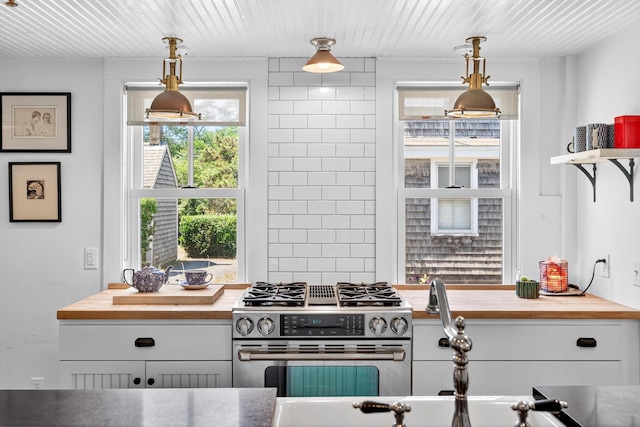 7 Anthony St, Provincetown, MA 02657 - kitchen with wood counters, stainless steel range with gas cooktop, white cabinets, pendant lighting, and wooden ceiling