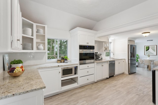 kitchen featuring white cabinets, light stone countertops, appliances with stainless steel finishes, and decorative backsplash