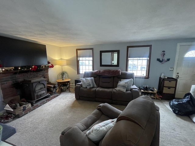 living room with a wood stove, a textured ceiling, and carpet flooring