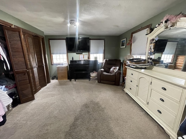 bedroom featuring a textured ceiling, a closet, and light carpet