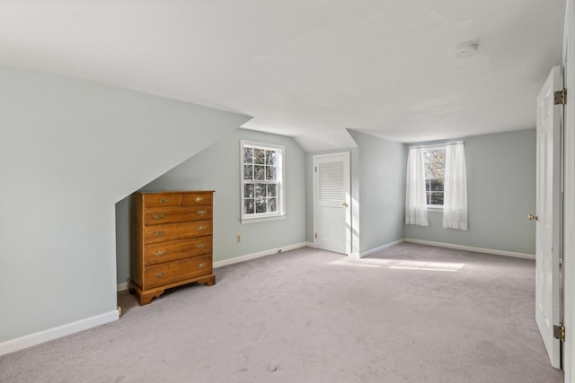 bonus room featuring light carpet and vaulted ceiling