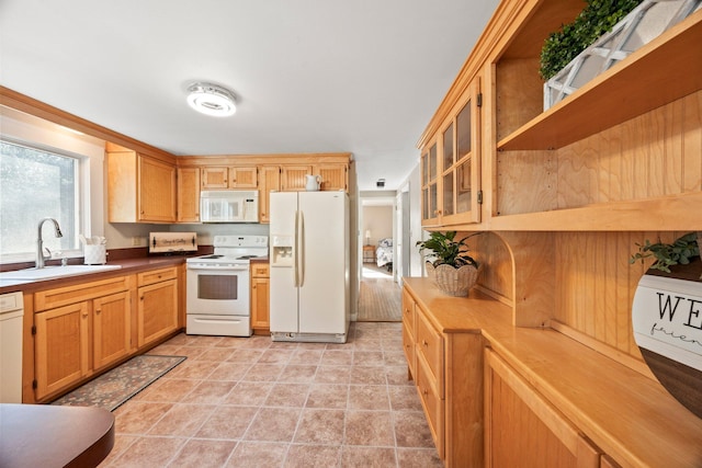 kitchen featuring sink, light tile patterned floors, and white appliances