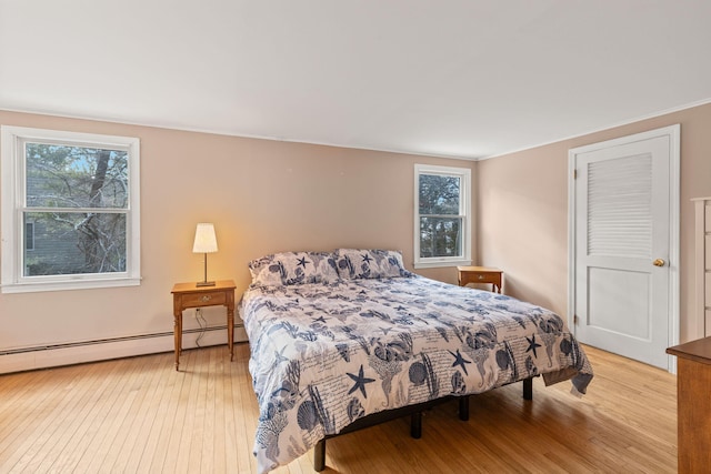 bedroom featuring light hardwood / wood-style floors and baseboard heating