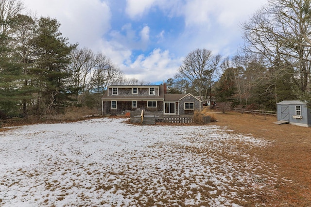 view of front of property with a wooden deck and a shed