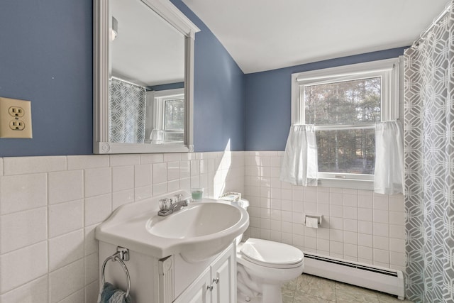 bathroom with tile walls, vanity, a baseboard radiator, tile patterned floors, and toilet