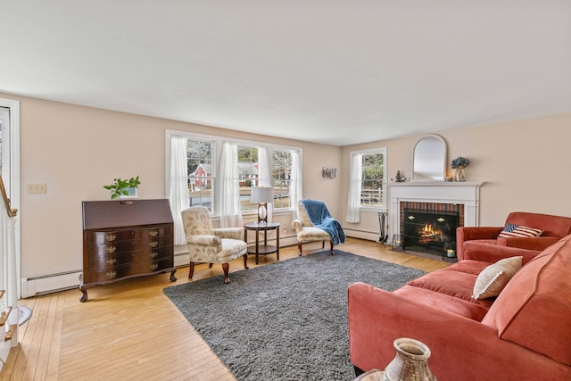 living room with hardwood / wood-style flooring, a baseboard radiator, and a brick fireplace