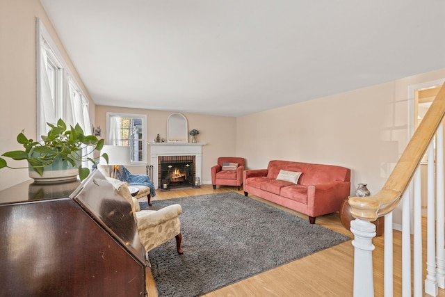 living room featuring hardwood / wood-style flooring and a brick fireplace