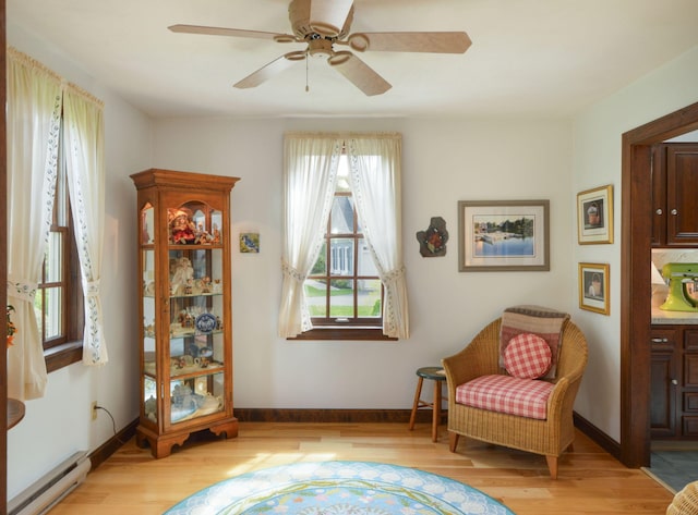 83 Colonial Way W, Falmouth, MA 02540 - living area with baseboard heating, light wood finished floors, a ceiling fan, and baseboards