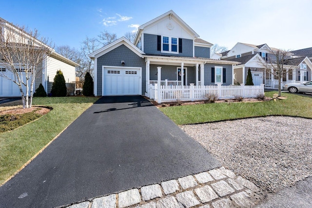 view of front of property with a garage, aphalt driveway, fence, a front lawn, and a porch