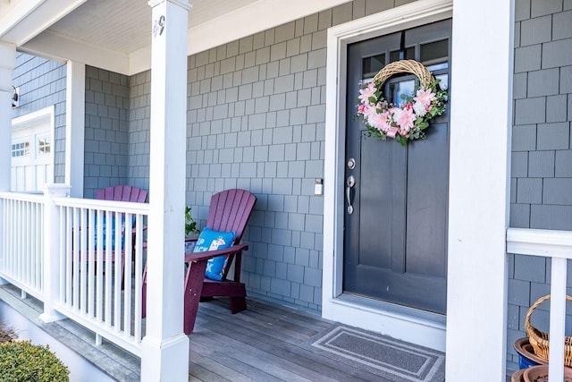 entrance to property featuring covered porch and visible vents