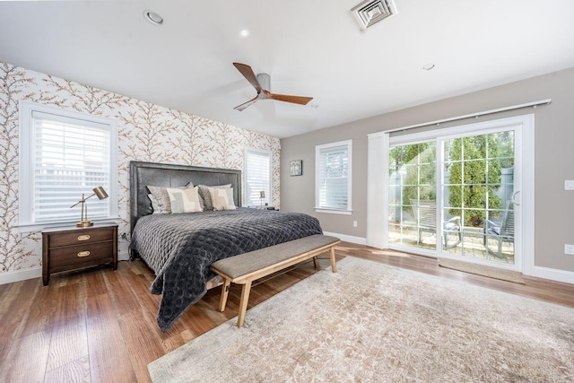 bedroom with multiple windows, visible vents, baseboards, and wallpapered walls