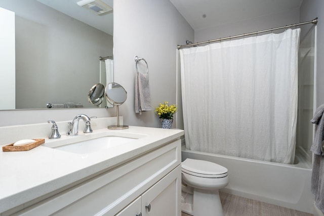 bathroom with visible vents, vanity, shower / bath combo with shower curtain, and toilet