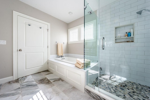 bathroom with marble finish floor, a garden tub, and a shower stall