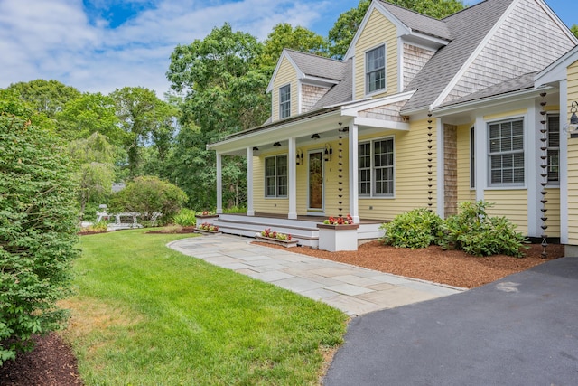 2 Julie Ln, Cotuit, MA 02635 - view of front of home featuring covered porch, a front lawn, and roof with shingles