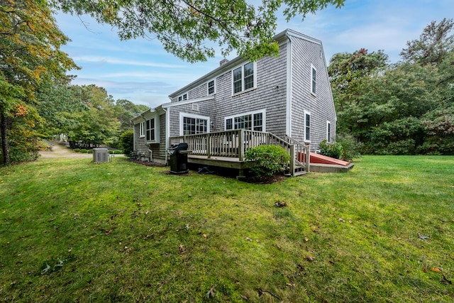 back of house with a yard, a deck, and central AC