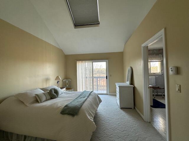 bedroom with lofted ceiling, multiple windows, light colored carpet, and access to exterior