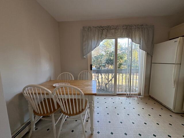 dining area with a baseboard heating unit and light floors