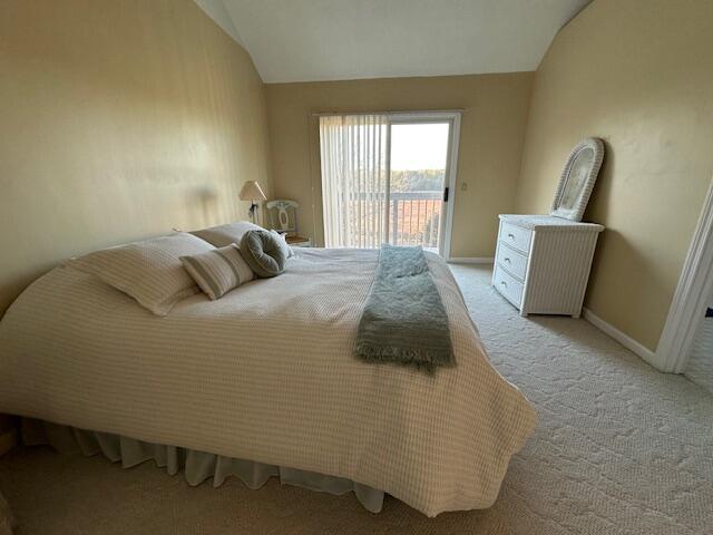 carpeted bedroom with lofted ceiling, access to exterior, and baseboards