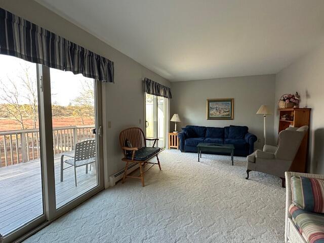 living area with carpet floors and a baseboard heating unit