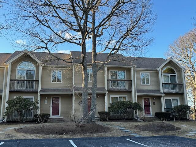 townhome / multi-family property featuring uncovered parking and a balcony