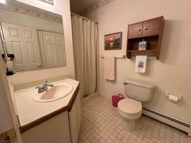 bathroom featuring toilet, a baseboard radiator, tile patterned floors, curtained shower, and vanity