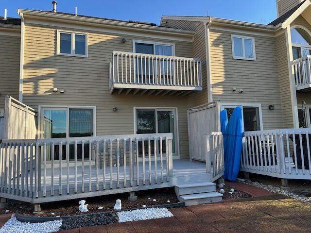 back of house featuring a wooden deck and a balcony