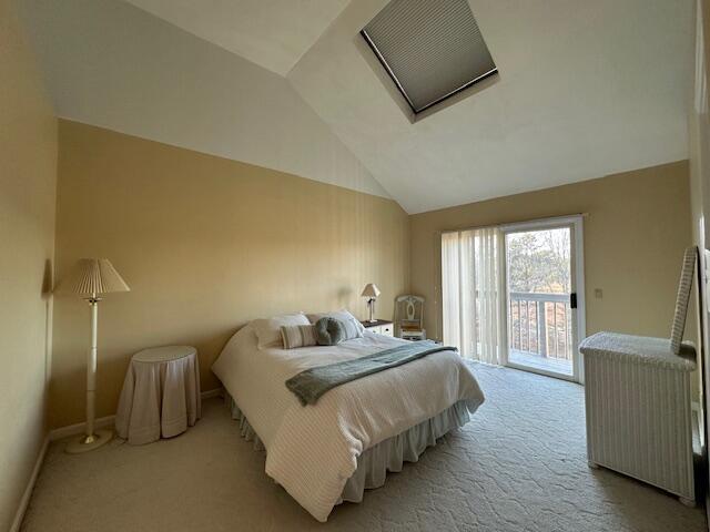 carpeted bedroom with vaulted ceiling, baseboards, and access to exterior