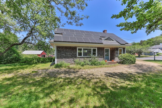 view of front facade with a front lawn and solar panels