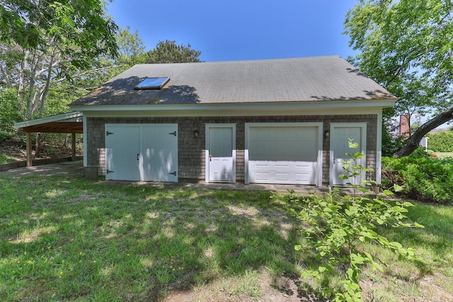 garage with a carport and a yard