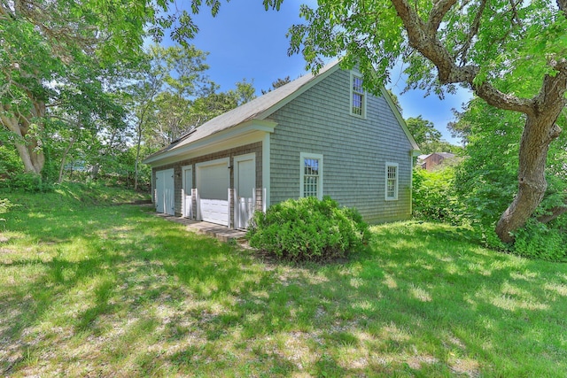 view of home's exterior with an outdoor structure, a yard, and a garage