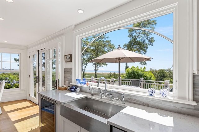 30 Tisquantum Rd, Chatham, MA 02633 - kitchen with beverage cooler, light stone countertops, light wood-style floors, ornamental molding, and recessed lighting