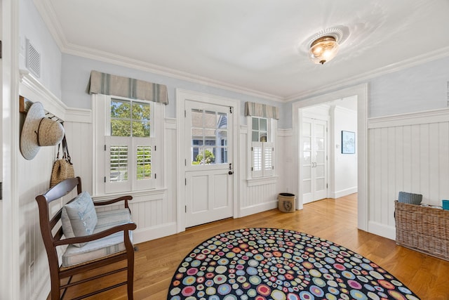 30 Tisquantum Rd, Chatham, MA 02633 - foyer featuring wood finished floors, healthy amount of natural light, a decorative wall, crown molding, and wainscoting