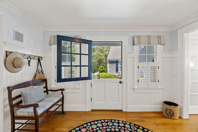30 Tisquantum Rd, Chatham, MA 02633 - doorway to outside featuring wood finished floors, a decorative wall, crown molding, and a wainscoted wall