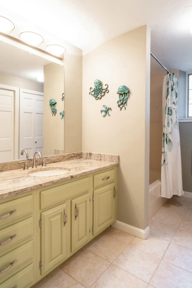 bathroom featuring shower / tub combo with curtain, vanity, baseboards, and tile patterned floors
