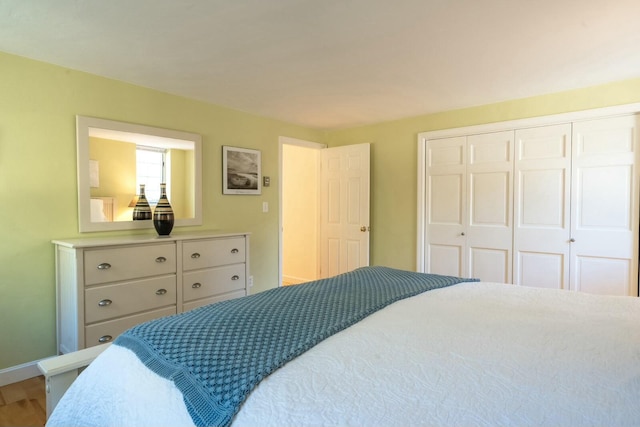 bedroom with a closet, baseboards, and wood finished floors