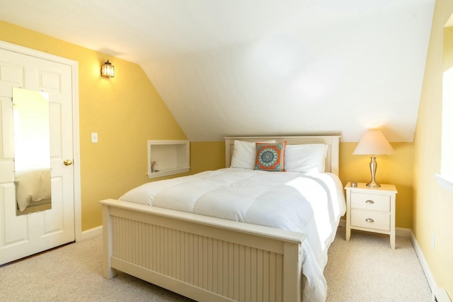 bedroom with light carpet, baseboards, and vaulted ceiling