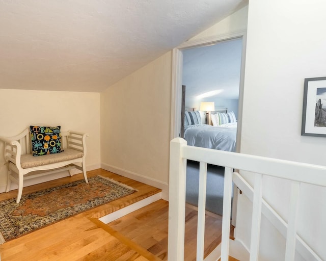 bedroom with lofted ceiling, wood finished floors, and baseboards