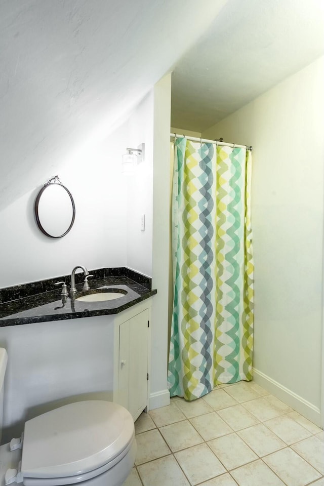 bathroom featuring baseboards, vanity, toilet, and tile patterned floors
