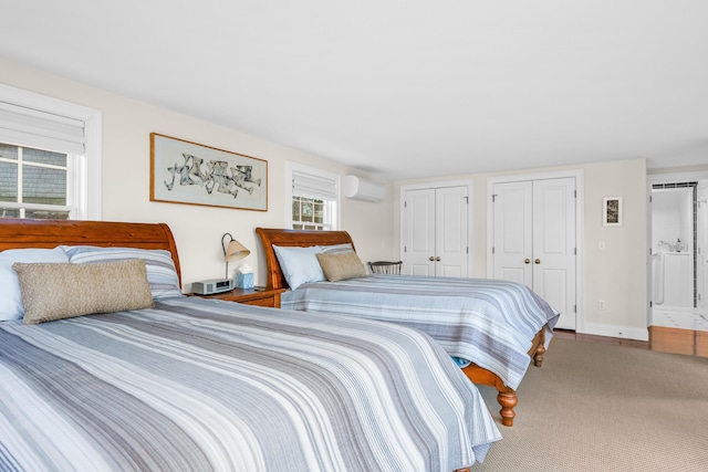 bedroom featuring two closets and a wall mounted AC