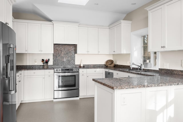 kitchen with a sink, white cabinetry, appliances with stainless steel finishes, a peninsula, and a skylight