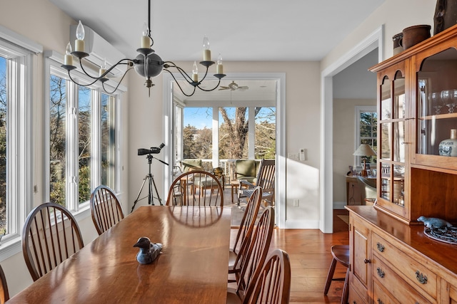 dining area featuring baseboards, wood-type flooring, and an inviting chandelier