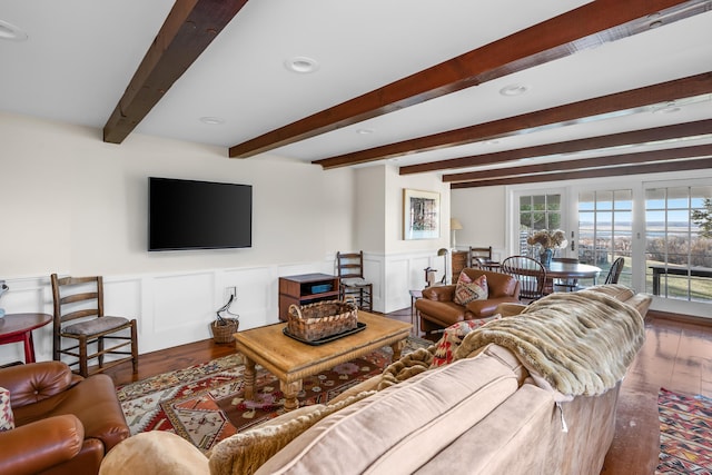 living area with recessed lighting, beamed ceiling, wood finished floors, and a wainscoted wall