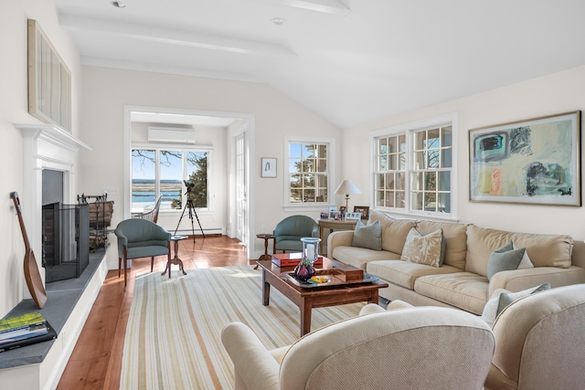 living area featuring a fireplace with raised hearth, a wall mounted air conditioner, vaulted ceiling, wood finished floors, and a baseboard radiator