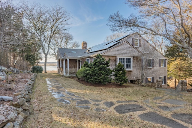 exterior space with solar panels, a sunroom, and a chimney