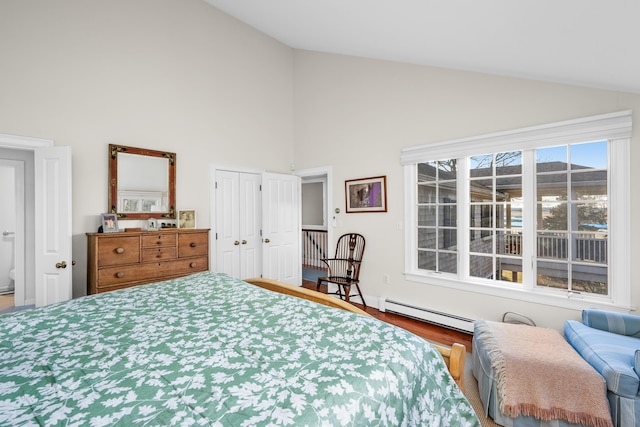 bedroom featuring a baseboard heating unit, wood finished floors, a closet, and high vaulted ceiling