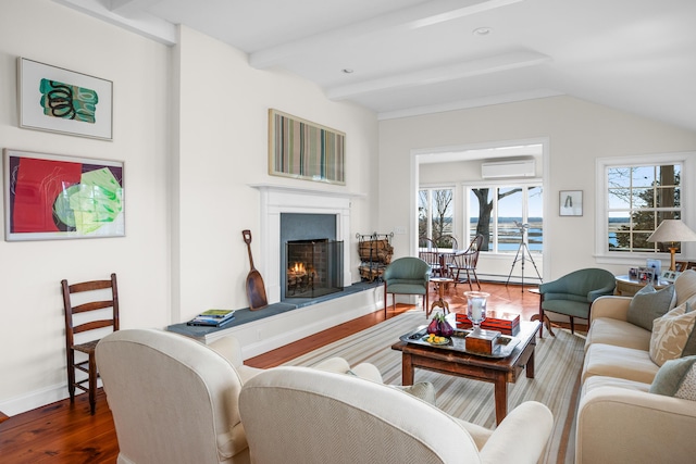 living room with a wall unit AC, wood finished floors, baseboards, lofted ceiling with beams, and a warm lit fireplace