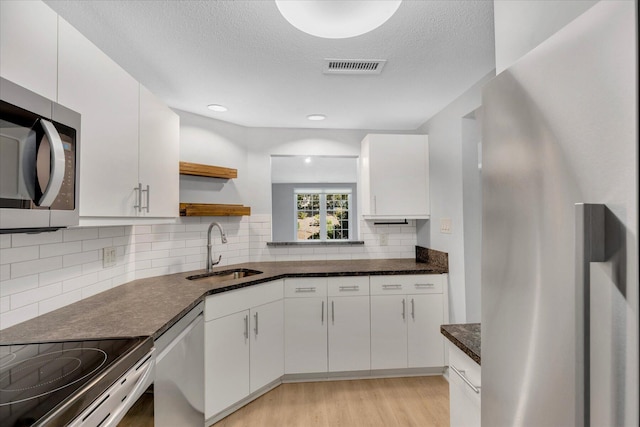 2124 Heatherwood, Yarmouth Port, MA 02675 - kitchen featuring a sink, stainless steel appliances, open shelves, white cabinetry, and light wood finished floors