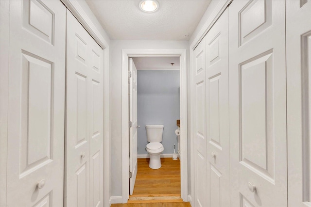 2124 Heatherwood, Yarmouth Port, MA 02675 - bathroom featuring a closet, toilet, baseboards, wood finished floors, and a textured ceiling