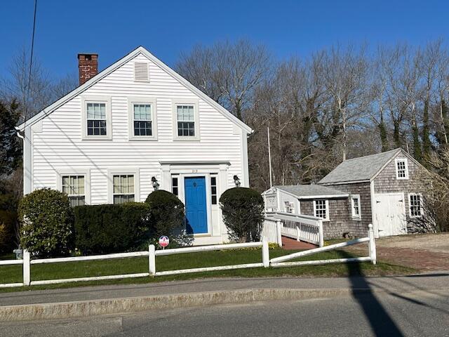 view of front of home featuring fence and a chimney